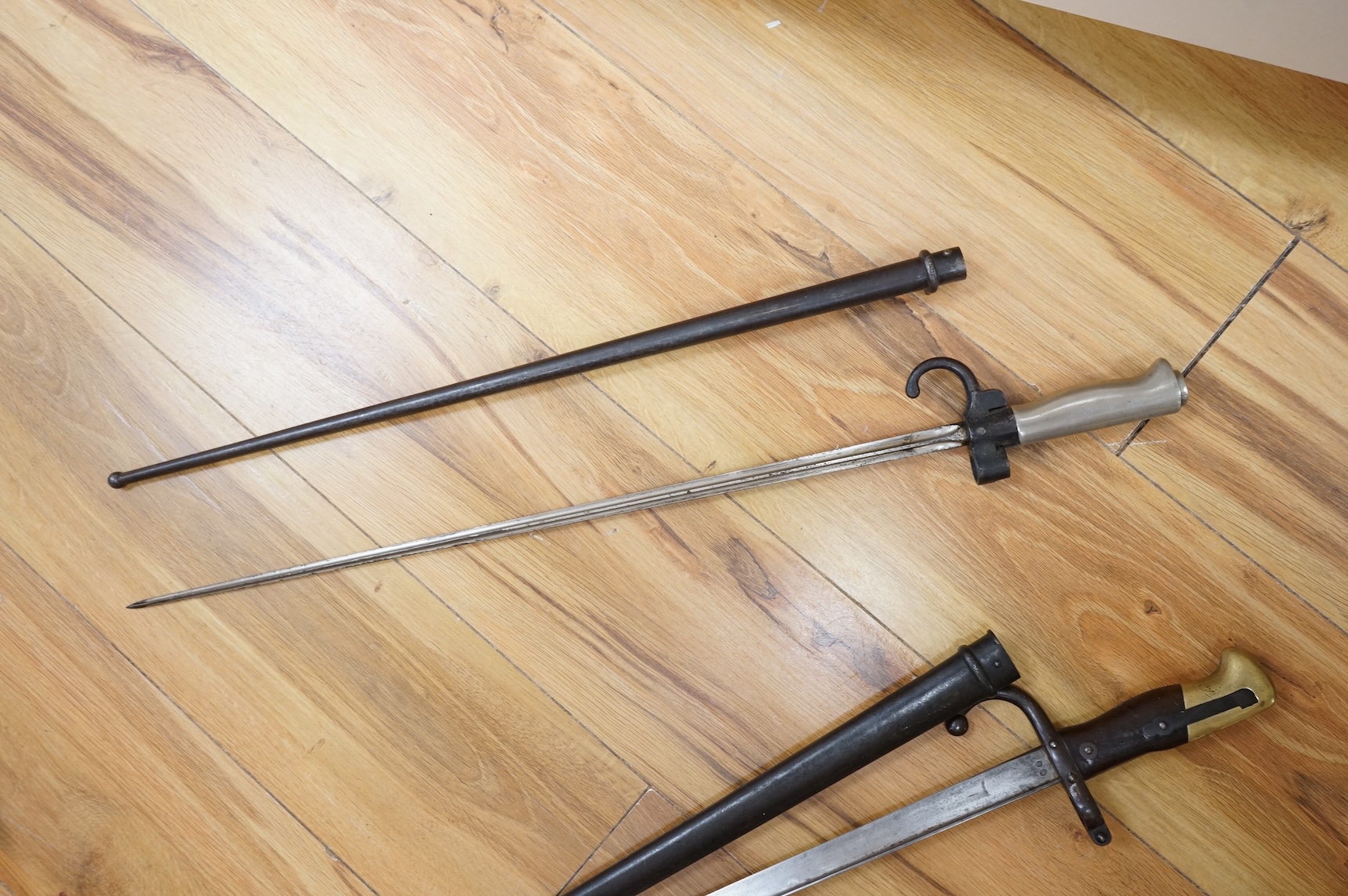 Three bayonets; a gras bayonet, a Lebel bayonet and an Indian Enfield style triangular socket bayonet, all in the original scabbards
